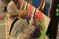 Équipe concentrée sur la réalisation d’un lettrage graffiti lors d’un atelier team building MadCityZen. | © MadCityZen